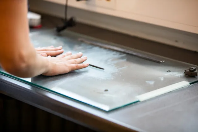 En leirprøve rulles ut til en tynn tråd på en glassplate.